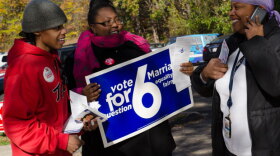 Sam, Karess and volunteer on Election Day. Karess holds up a sign that reads "Vote for Marriage Equality & Fairness - question 6."