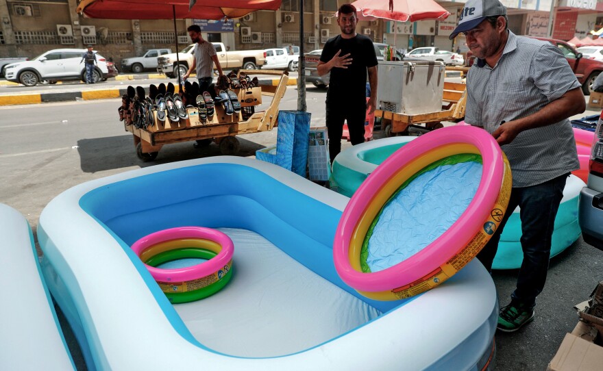 A shopkeeper sells children's inflatable tubs on a street in Baghdad on June 30, 2021 during a severe heat wave.