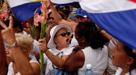 Laura Pollan (center), leader of the Cuban dissident group Ladies in White, is surrounded by government supporters after Sunday Mass in Havana on April 25.