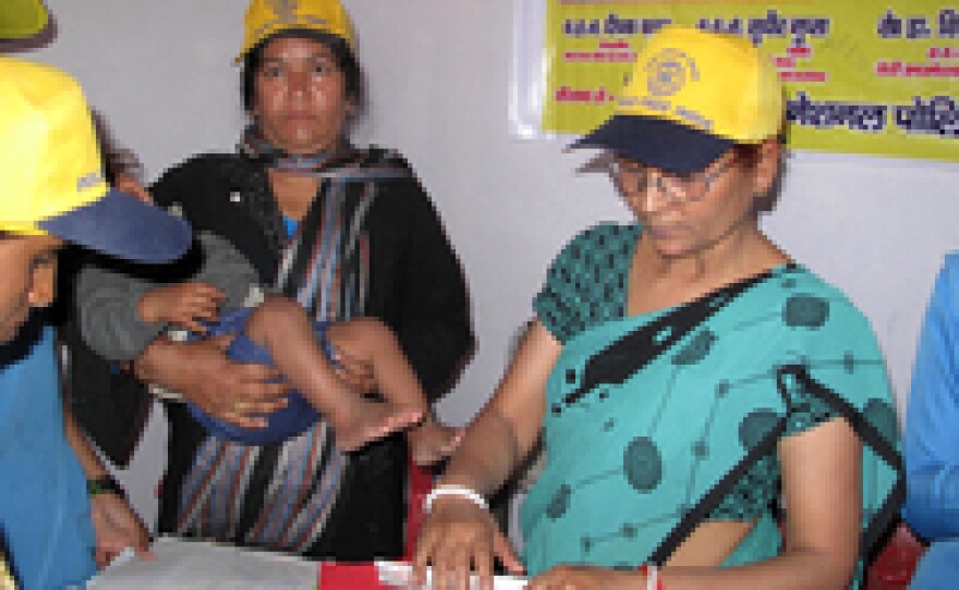 Polio vaccine campaigns are no longer just for fighting polio: Here health workers give a baby a shot against the measles in Moradabad, India.