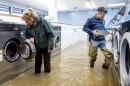 Pamela and Patrick Cerruti empty coins from Pajaro Coin Laundry as floodwaters surround machines in the community of Pajaro in Monterey County, Calif., Tuesday, March 14, 2023. "We lost it all. That's half a million dollars of equipment," said Pamela who added that they plan to rebuild.