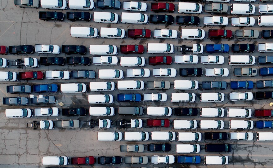 In this aerial photo, pickup trucks and vans are seen in a parking lot outside a General Motors assembly plant where they are produced, March 24, in Wentzville, Mo. A key component in the car industry is in short supply: computer chips. Taiwan's chipmakers are racing to meet demand.