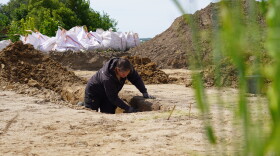 An archaeologist excavates a Viking Age pit house in Aarhus, Denmark, on June 22, 2026.
