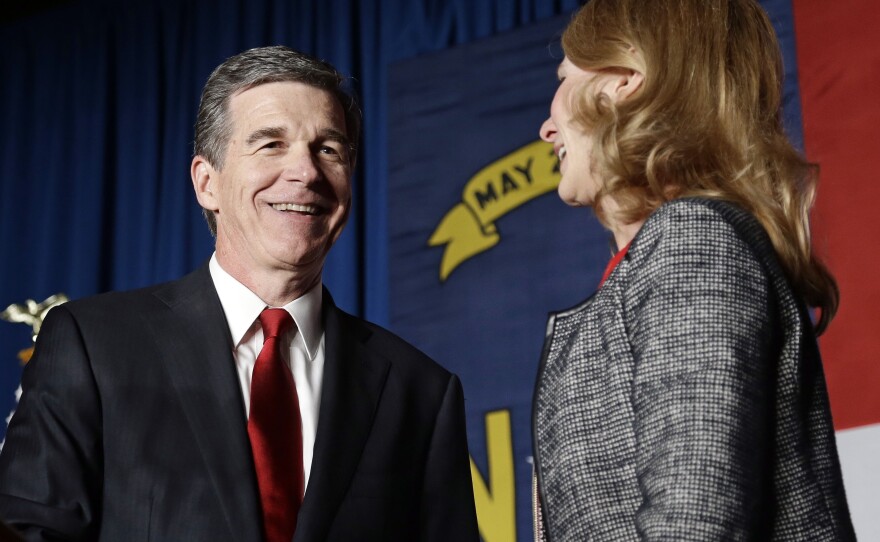 Democratic challenger Roy Cooper has a lead of more than 6,000 votes over Gov. Pat McCrory. He's seen here with his wife, Kristin, at an election night rally in Raleigh.