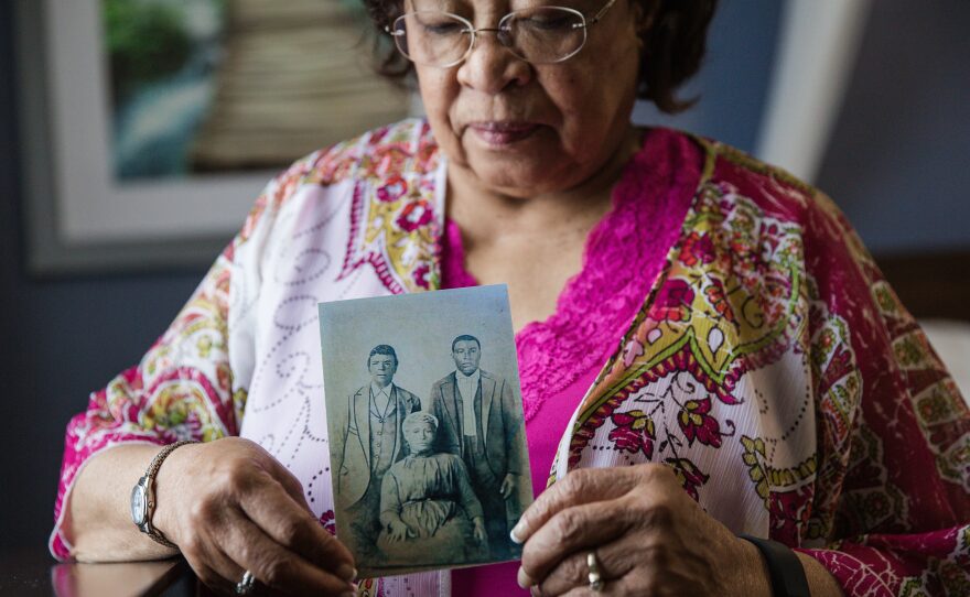 Patricia Bayonne-Johnson holds a photo of her great-grandparents and their son. The retired science teacher discovered that some of her ancestors were sold by the Jesuits of the Maryland Province in 1838, to pay off Georgetown University's massive debt.