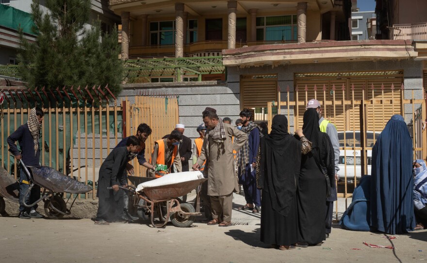 Women wait outside the distribution center where the World Food Programme is giving food assistance in October.