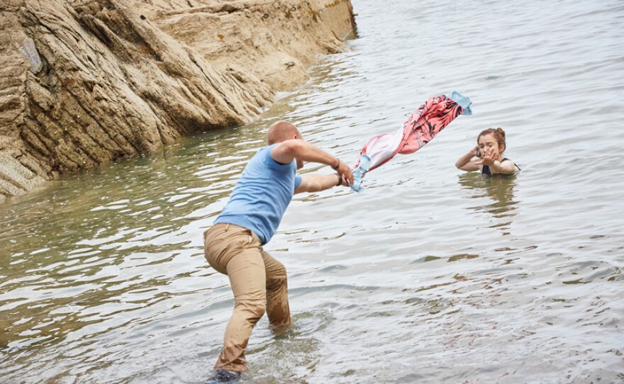 Davey (Matt Bardock) attempts to pull Beth (Grace Hogg Robinson) out of the water with the towel in a scene from “The Drop Zone.”