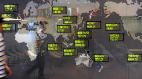 A man walked past a billboard showing global stock indices at the Taiwan Stocks Exchange in Taipei as markets extended losses Tuesday.
