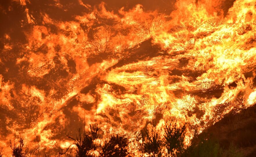 Flames engulf a hillside Thursday in Lake Elsinore, Calif. Firefighters say the blaze, which has burned through more than 10,000 acres and forced the evacuations of 20,000 people, is just 5 percent contained.