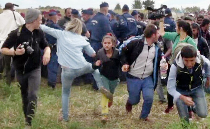 A video grab from Sept. 9, 2015, shows Petra Laszlo, a Hungarian camerawoman, kicking a child running with other migrants from a police line in southern Hungary. She also tripped Osama Abdul Mohsen, running with son Zaid in his arms.