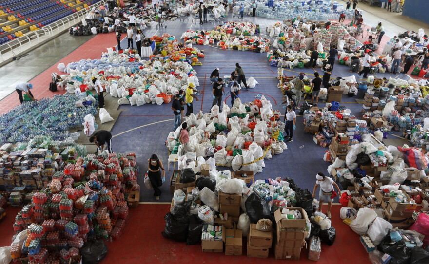 Volunteers sort aid for people affected by the earthquake in Cali, Colombia, Wednesday, Aug. 12, 2026.