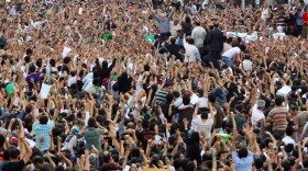 Defeated reformist presidential candidate Mir Hossein Mousavi (C) raises his arms as he appears during a demonstration in the streets on June 15, 2009 in Tehran, Iran. Crowds of people gathered to protest the re-election of Iran's President Mahmoud Ahmadinejad, who won a second four-year term in a landslide election victory on June 12. 