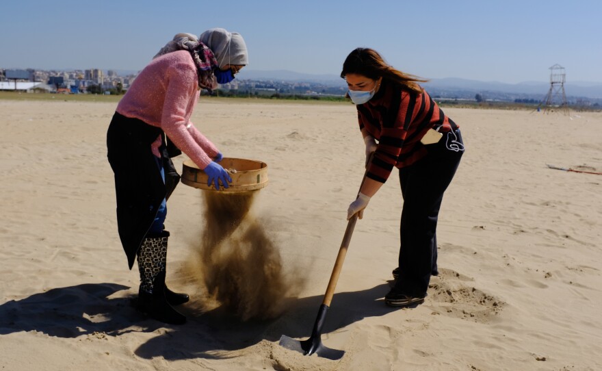 Marine biology student Ranim Tahhan, 21, pictured left, and another volunteer work to clean Tyre beach from the pollution caused by an oil spill in the eastern Mediterranean Sea.