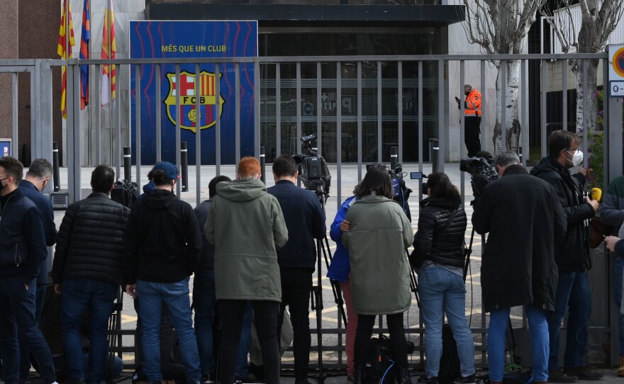 Journalists line the front gate of FC Barcelona offices on Monday during a police operation inside.