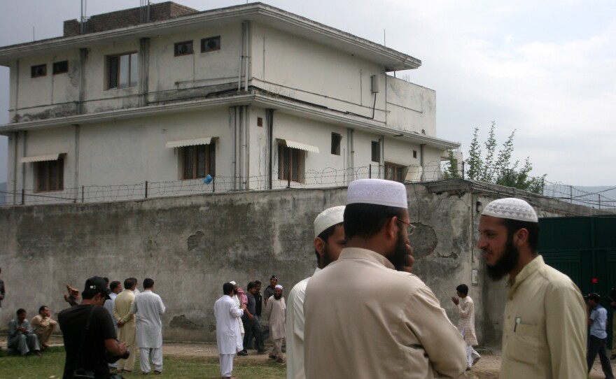 Local residents and media are seen on May 5, 2011, outside the house where Osama bin Laden was caught and killed days earlier in Abbottabad, Pakistan.