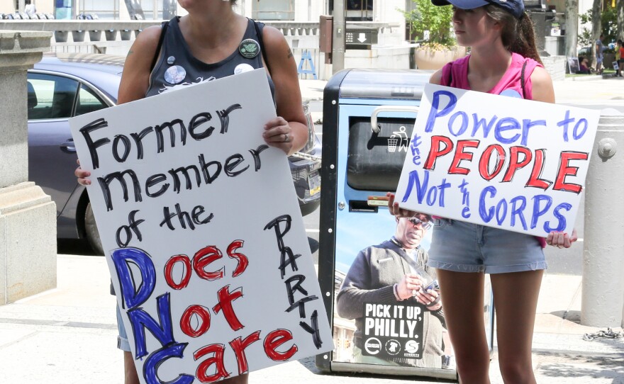 "I knew it already. I knew it," Laura Hockenberry said of news that DNC officials tried to undercut Sanders' campaign. She held a sign reading "former member of the Does Not Care party" during Sunday's march in Philadelphia.