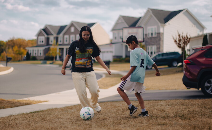 Kripal Khatiwoda, 10, plays soccer with his sister, Christina Khatiwoda, 14, in their front yard in Harrisburg, Pa., on Sept. 14, 2025. Kripal participates in ARU's Soccer for Success program.