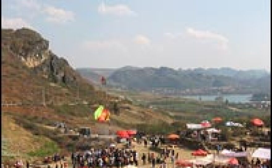 The Flower Mountain Festival takes place in a clearing marked by a flagpole in China's southern Yunnan province.