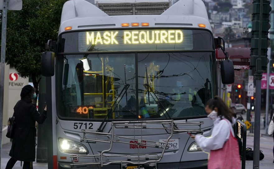 A sign on a San Francisco bus advises that passengers are required to wear masks. Health officials have renewed pleas for Americans to protect themselves and others from the coronavirus as the death toll passes 250,000.