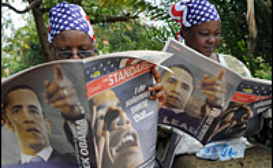 Kenyan women in Kisumu read a special edition of the <em>Standard</em> newspaper hours before Obama's inauguration.