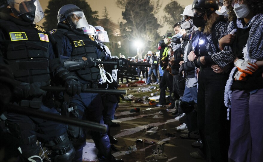 Police face off with pro-Palestinian students after dismantling part of the encampment barricade on the campus of the University of California, Los Angeles, early on May 2.