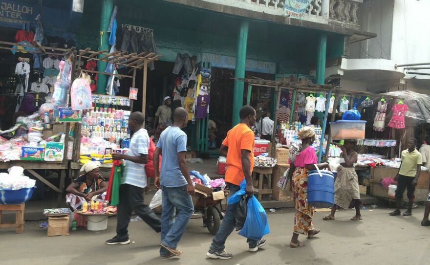 People walk past shops along a street in Liberia, where daily routines are returning to normal following a deadly Ebola outbreak, Jan. 2015.