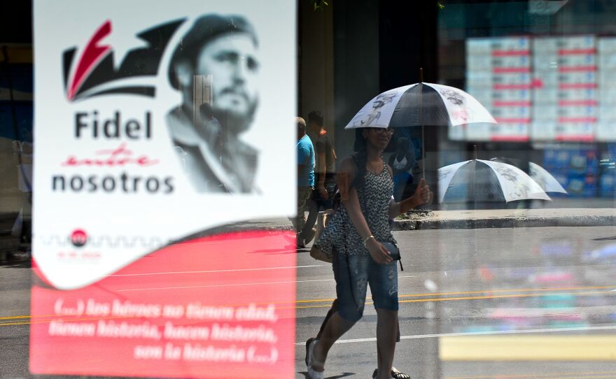 A woman in Havana walks next to a poster about Cuban former President Fidel Castro in August.