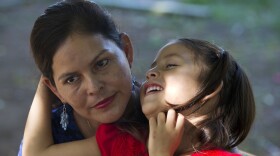 Araceli Ramos holds her 5-year-old daughter, Alexa, on her lap during an interview in a park in San Miguel, El Salvador, on Aug. 18, 2018.