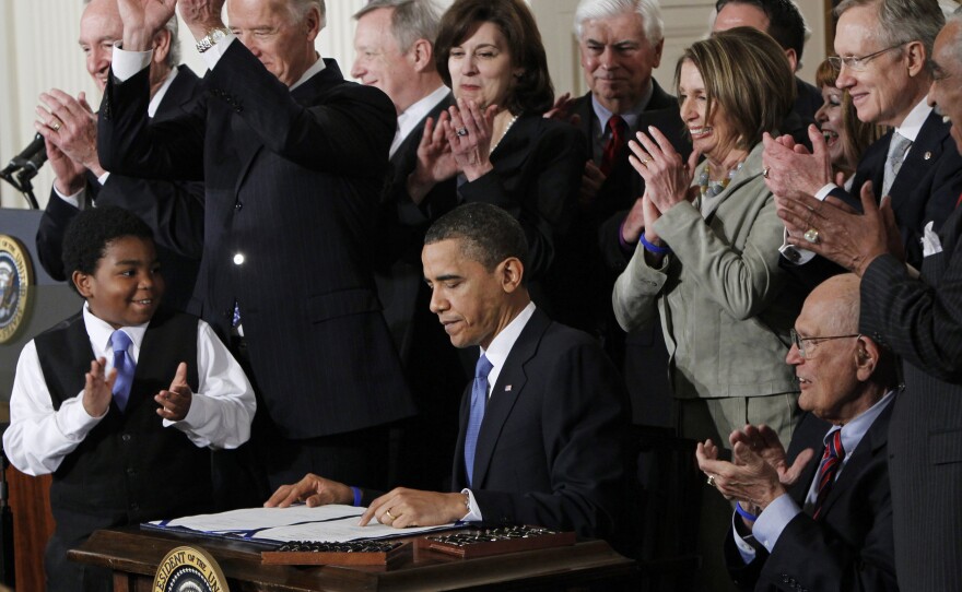 President Barack Obama is applauded after signing the Affordable Care Act into law on March 23, 2010.