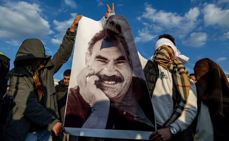 FILE - Youngsters hold a photograph of Abdullah Ocalan, the jailed leader of the militant Kurdish group, or PKK, in Diyarbakir, Turkey, Feb. 27, 2025.
