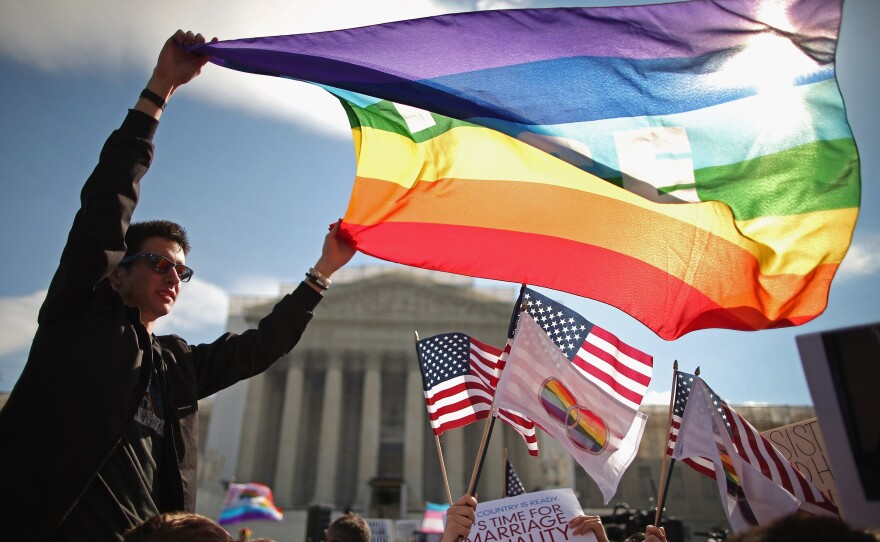 In her new book, <em>Forcing the Spring,</em> investigative reporter Jo Becker goes behind the scenes in the fight for marriage equality. Above, Eric Breese of Rochester, N.Y., joins hundreds of others to rally outside the Supreme Court during oral arguments in a case challenging the Defense of Marriage Act on March 27, 2013.