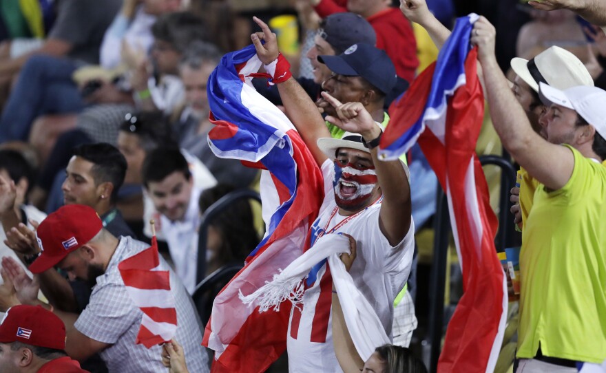 Fans cheer during the final round match between Monica Puig of Puerto Rico and Angelique Kerber of Germany at the 2016 Summer Olympics in Rio de Janeiro, Brazil.