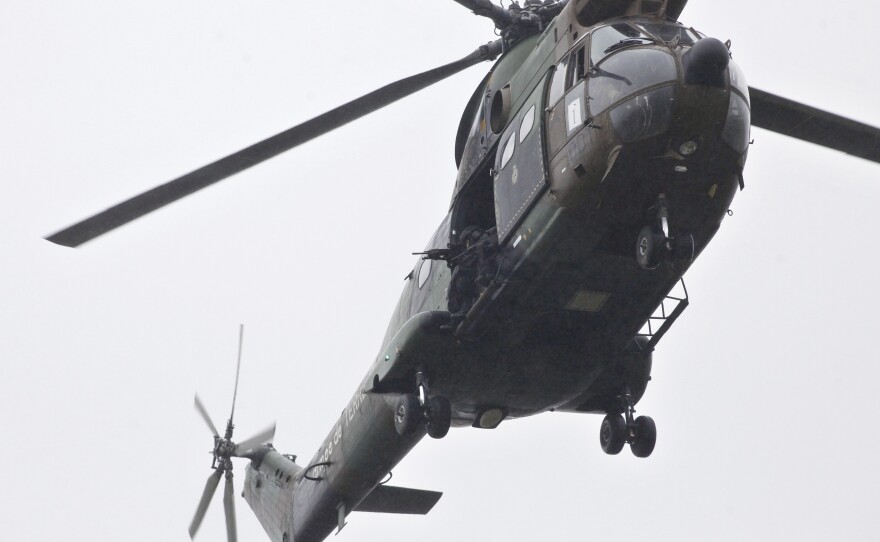 Armed security forces fly overhead in a military helicopter in Dammartin-en-Goele, northeast of Paris, on Friday.