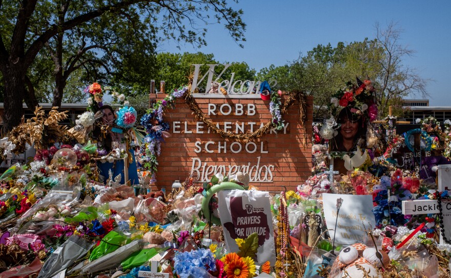 The Robb Elementary School sign is seen covered in flowers and gifts in Uvalde, Texas on June 17.