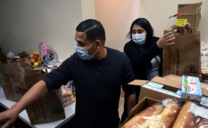 Ingmar Riveros and Peruvian refugee Xiomy De la Cruz distribute food from a store basement last month in Hartford, Conn.