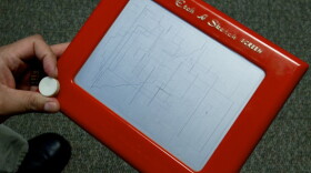 Rick Santorum beats up Mitt Romney with an Etch A Sketch, figuratively speaking.