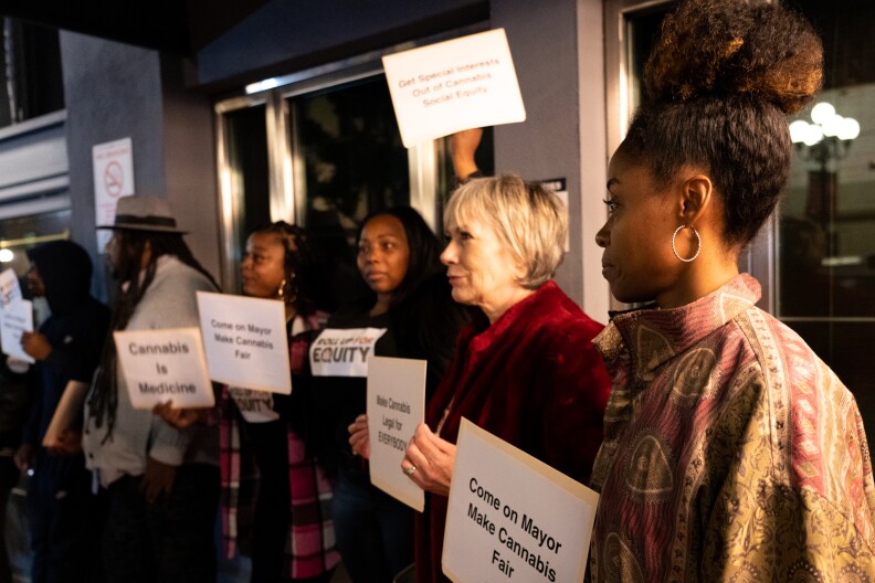 Cannabis business owner JM Balbuena (right) stands with cannabis equity protestors outside Mayor Todd Gloria's annual state of the city address at Balboa Theatre on Wednesday, Jan. 10, 2024.