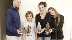 Rob, Enzo, Lizette and Sophia Greco holding plush toy headless pigeons made from recycled fabrics.
