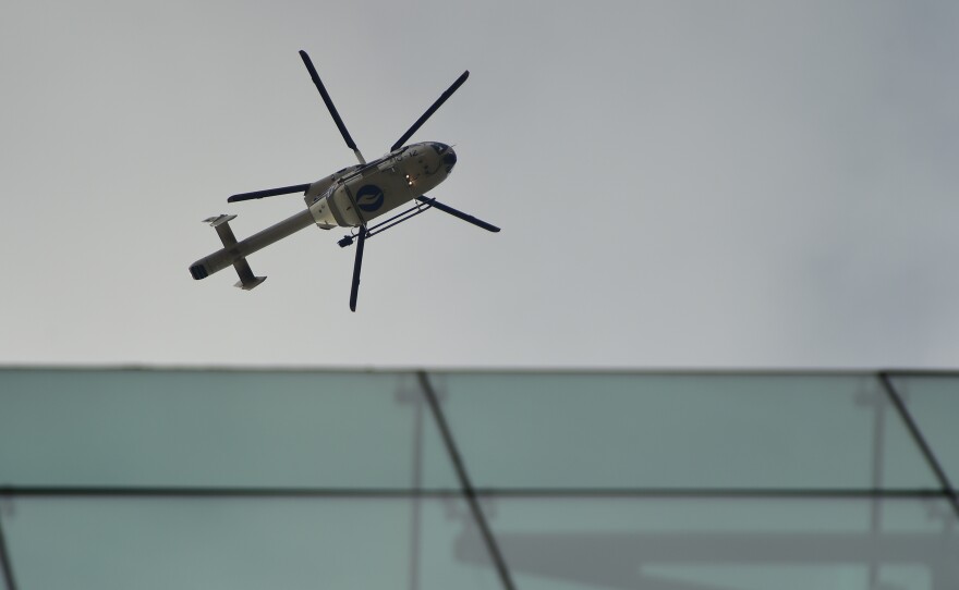 A police helicopter flies in the area of the Maelbeek metro station in Brussels after a blast Tuesday. Trains were halted, and the city is under a lockdown.