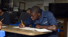Quartermaster Seaman Jonathan Roundtree takes the E-4 advancement exam on the mess decks aboard the mine countermeasures ship USS Warrior. 