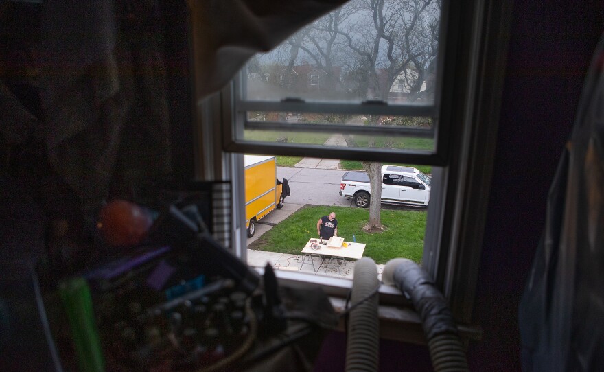 J.R. Cassidy, from the company Weatherization Rx, installs energy-saving upgrades in Flora Dillard's house in Cleveland.