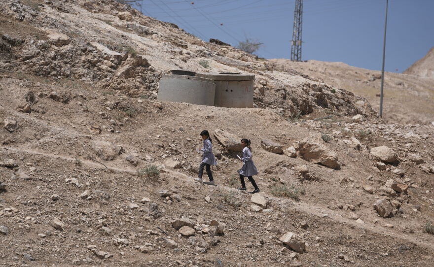 Palestinian students walk on their way home after receiving their year end reports from school, in the West Bank Bedouin hamlets of Khan al-Ahmar, Wednesday, June 10, 2026.