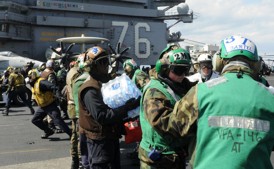 PACIFIC OCEAN (March 19, 2011) Sailors and Marines aboard the aircraft carrier USS Ronald Reagan (CVN 76) load humanitarian assistance supplies onto an HH-60H Sea Hawk helicopter assigned to the Black Knights of Anti-Submarine Squadron (HS) 4.