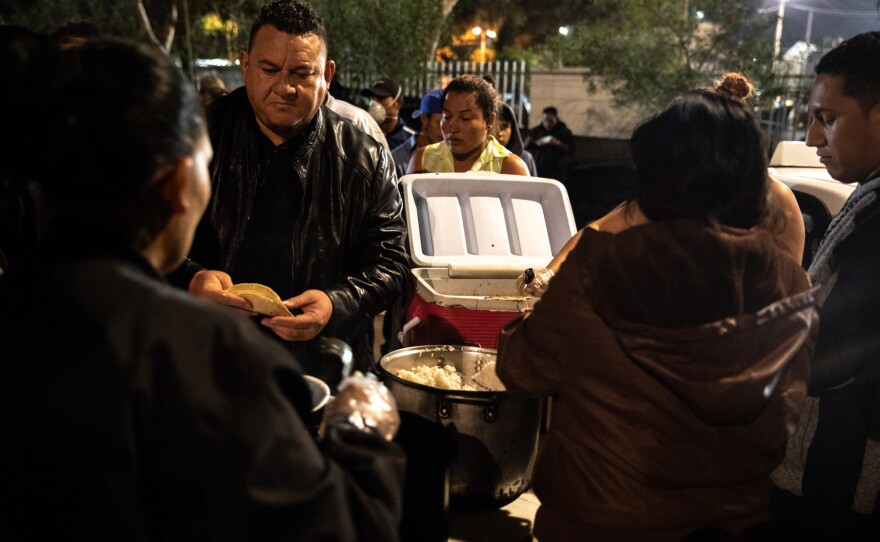 With the help of his family and employees, José Aguilar delivers five containers of a hearty Honduran-style chicken stew to the caravan.