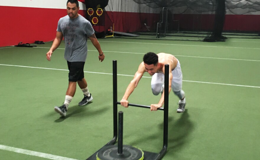 Badminton player Howard Shu pushes a weight sled designed to help improve his speed and explosive power on the court. Shu, 25, of Anaheim, Calif., will be the sole U.S. men's singles player in badminton at the Olympics.