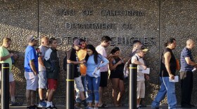 People line up at the California Department of Motor Vehicles prior to opening in the Van Nuys section of Los Angeles on Tuesday, Aug. 7, 2018. 