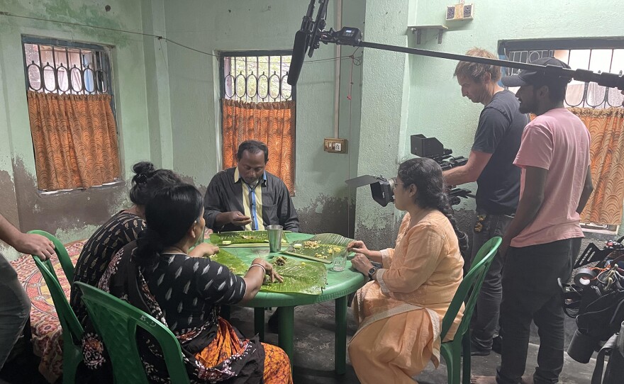 Cinematographer Dave Pearson filming researcher Dhruba Gupta and family in Kolkata, India.