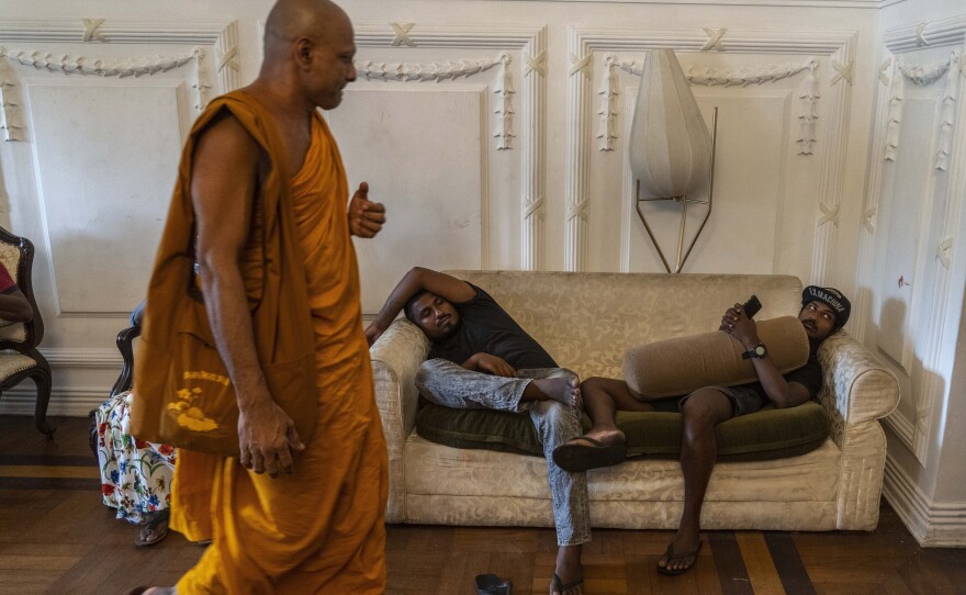 People rest on a sofa at the prime minister's official residence on the second day after it was it was stormed in Colombo, Sri Lanka, on Monday.