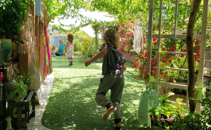 Kids run in the backyard of Liberty Winn's childcare center in Carlsbad, May 18, 2022.