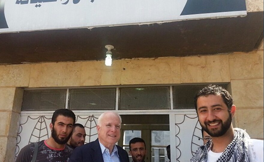 In this Monday, May 27, 2013 photo provided by Mouaz Moustafa and the Syrian Emergency Task Force, Sen. John McCain, R-Ariz., center, accompanied by Moustafa, right, visits rebels in Syria. McCain, who slipped into the country for a surprise visit, favors providing arms to rebel forces in Syria.